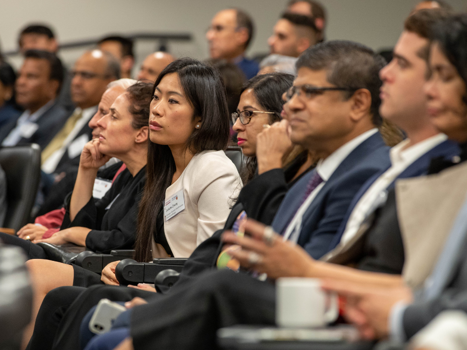MBA students in a lecture hall, attentively listening.