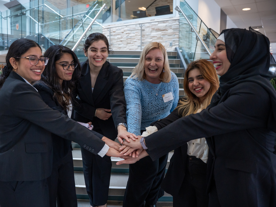 A group of MBA students laughing and smiling together.