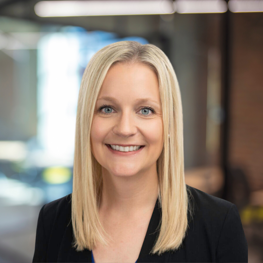 Headshot of Jenna Wood, a smiling woman with blonde hair, wearing a black blazer.
